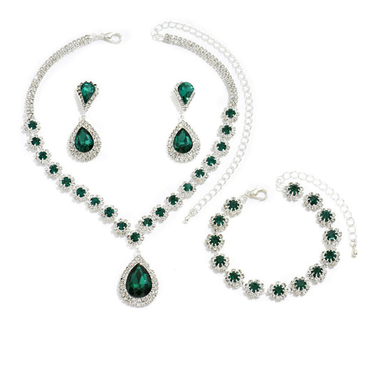 Green gemstone jewelry set including necklace, bracelet, and earrings on a white background