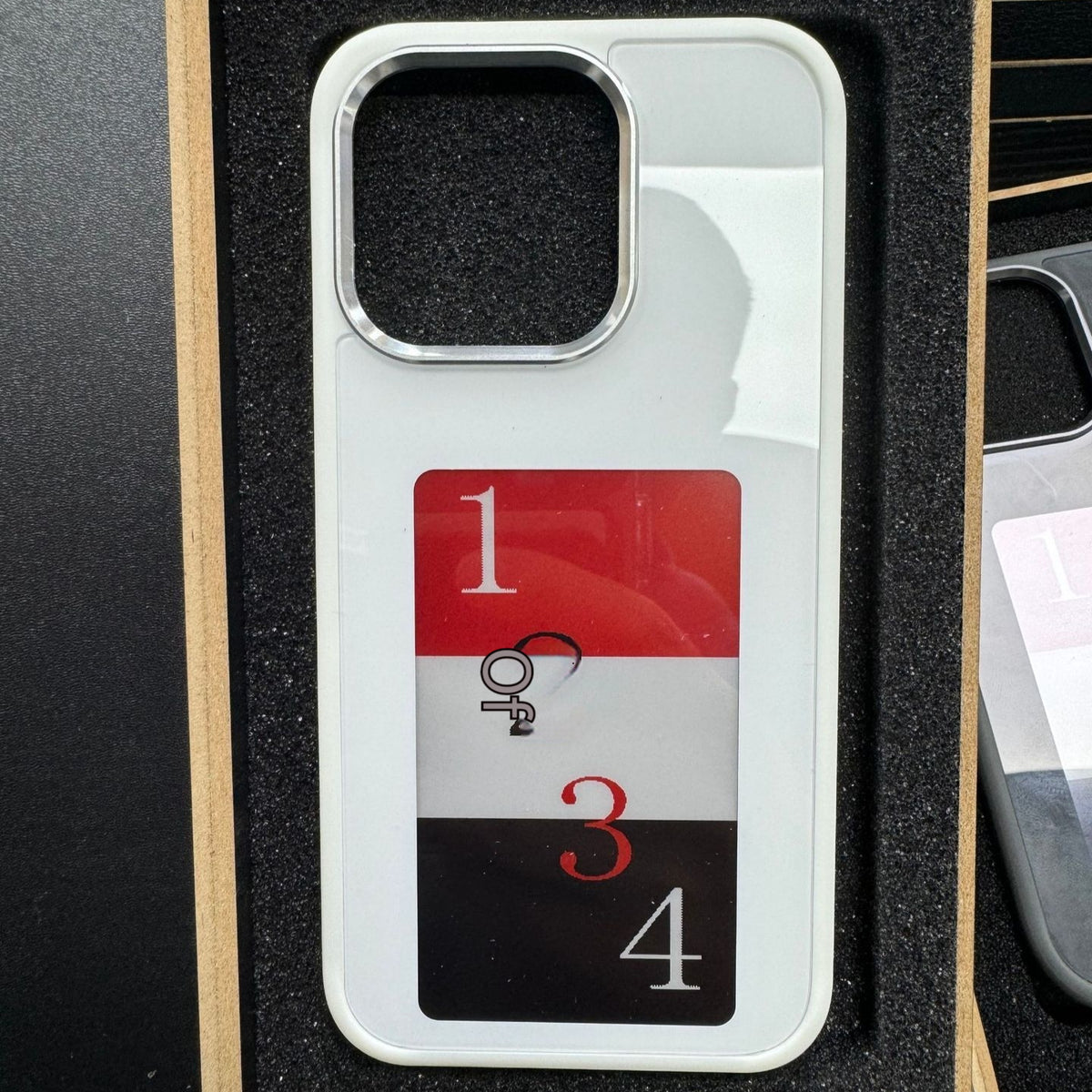 E-ink smart display phone case, white back with numbered e-ink display and camera cutout