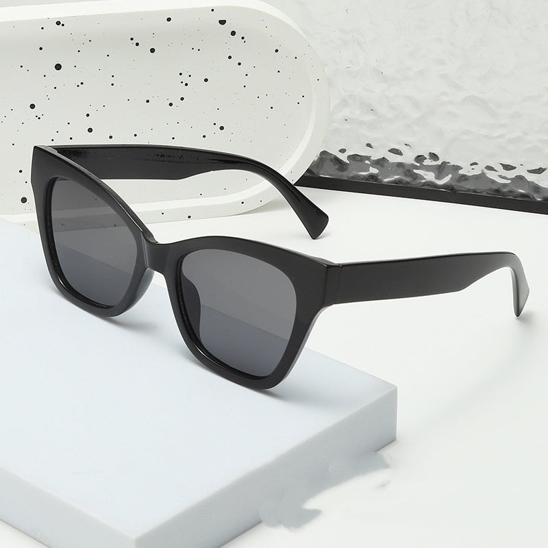 Black sunglasses with gray-tinted lenses and wide angular cat-eye shape