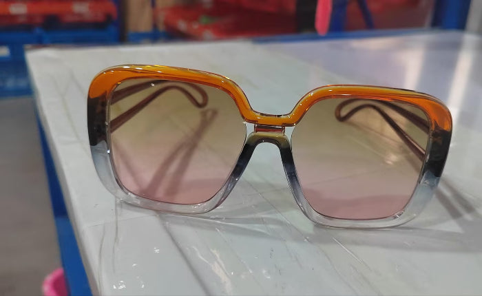 Large square sunglasses with amber frame and light pink tinted lenses