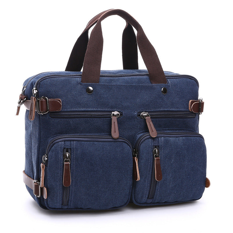 Blue canvas bag with top handles, front zip pockets, and leather-trim zipper pulls