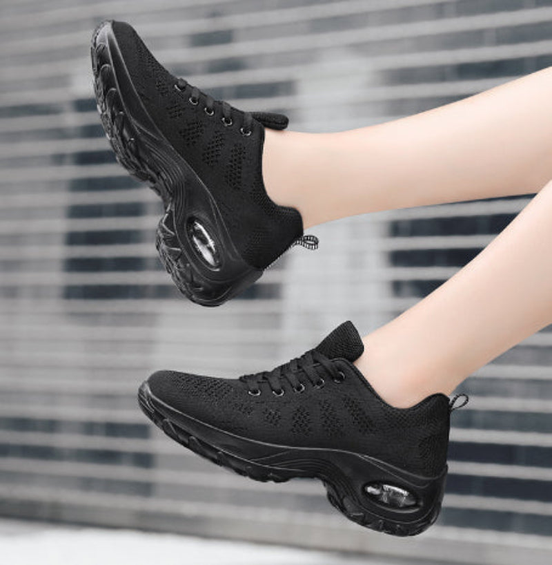 Black knit walking sneakers with oval air-cushion window and thick tread sole