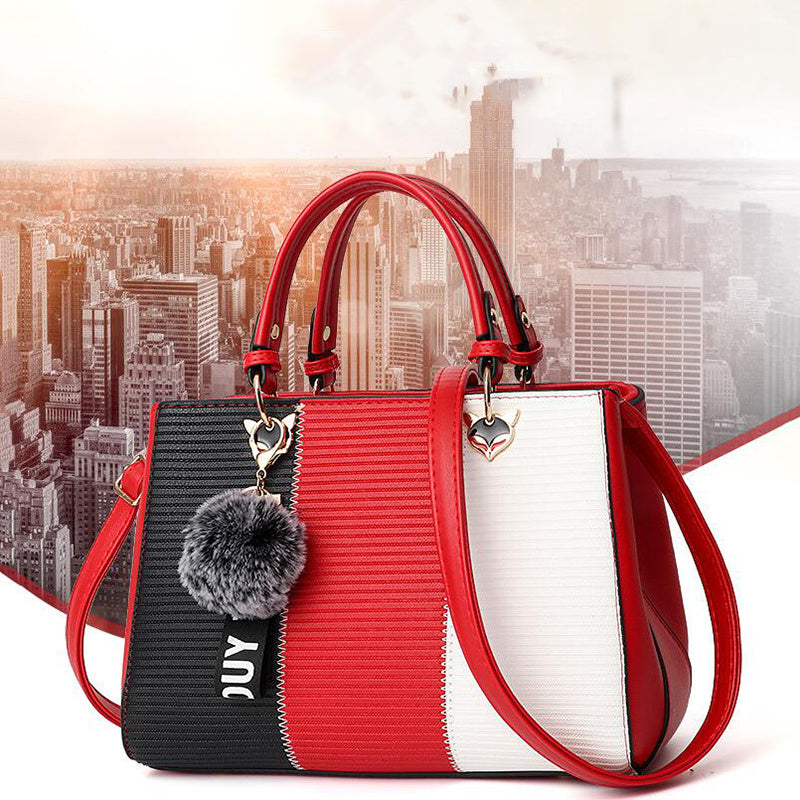 Red, black, and white color-block PU leather handbag with pompom charm and crossbody strap