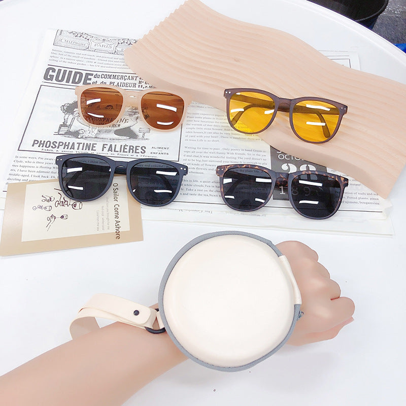 Amber-gold polarized folding sunglasses with dark lenses, shown with protective case