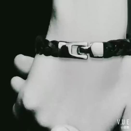 Close-up of a braided leather bracelet on a wrist with a blurred background