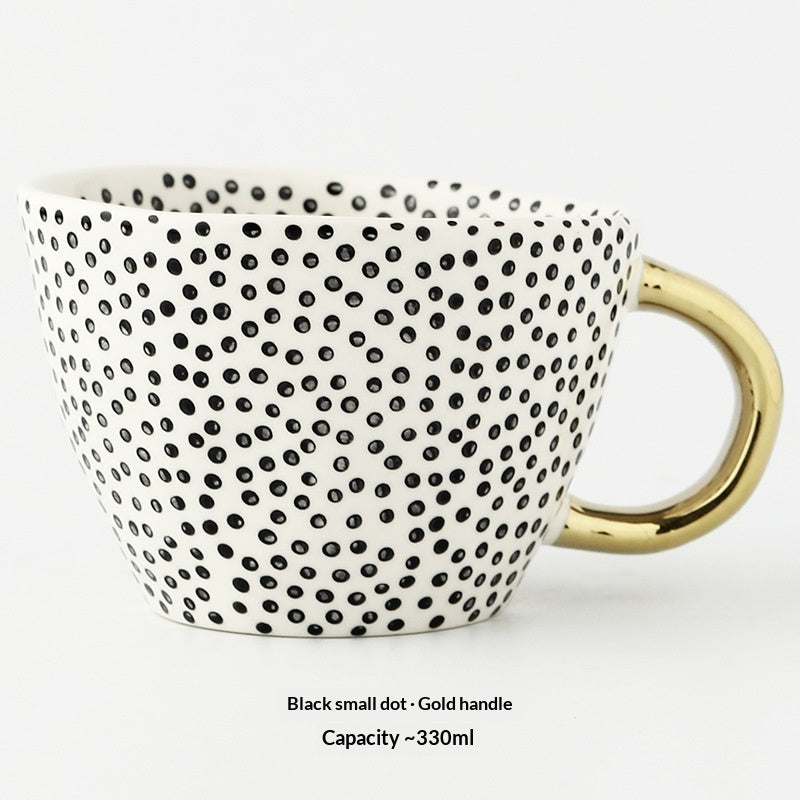 Ceramic mug with scattered small black dots and gold handle