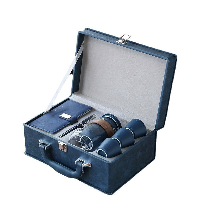 Blue office gift set case open: notebook, pen, thermos bottle, and tea cup set