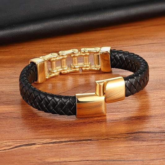 Black braided leather bracelet with gold clasp on a wooden surface