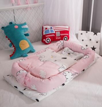 Portable baby nest crib with pink animal print mattress and coordinating pillow set