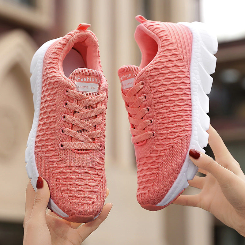 Coral pink knit running shoes with laces and white cushioned sole