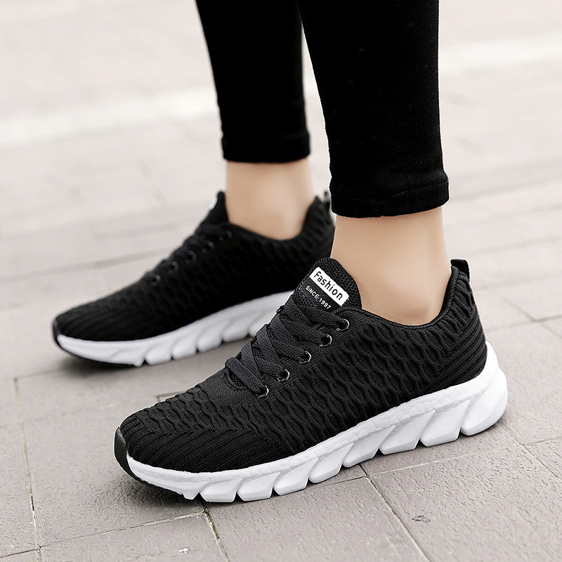 Black knit running shoes with laces and white cushioned sole