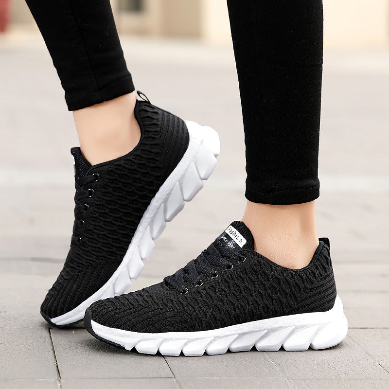 Black knit running shoes with laces and chunky white cushioned sole