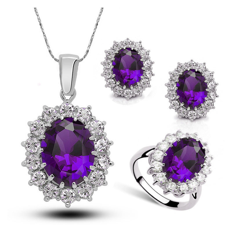 Crystal bridal jewelry set with purple round halo gemstones on necklace, earrings, and ring, silver.