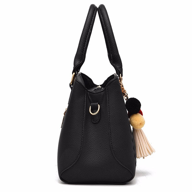 Women's crossbody handbag, black PU leather with tassel pom charm and front pocket