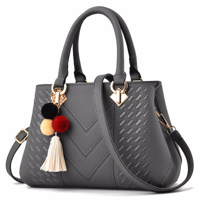 Women's crossbody handbag, grey PU leather with pom tassel charm and gold-tone hardware