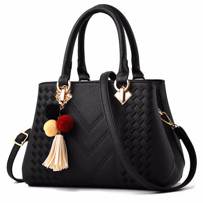 Women's crossbody handbag, black PU leather with shoulder strap, pom tassel, gold hardware