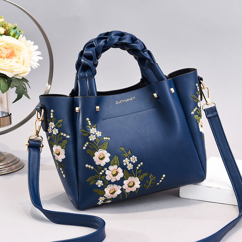 Floral PU handbag tote in navy blue with braided handles, floral embroidery, crossbody strap