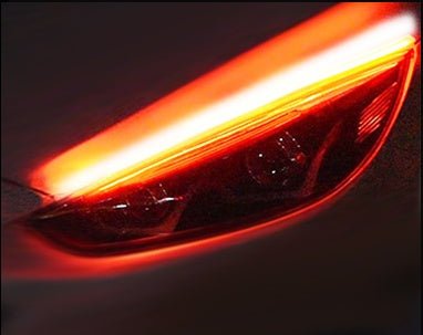 Car LED daytime running light strip close-up with warm orange glowing bar