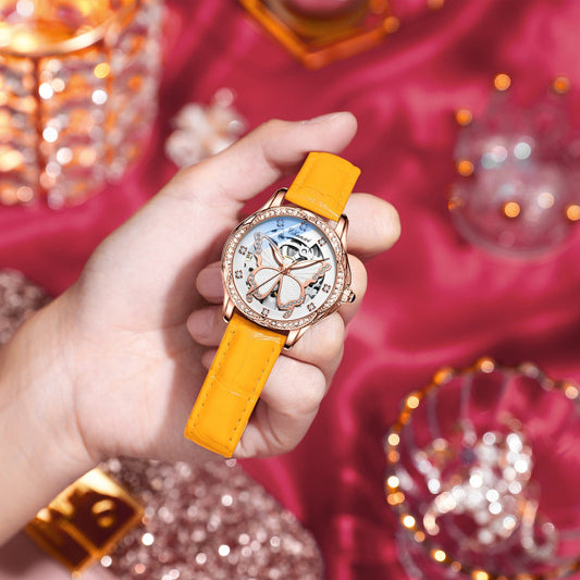 Hand holding a watch with a yellow strap. YAXSO UAE ONLINE STORE