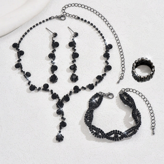 Black beaded jewelry set including necklace, bracelet, ring, and earrings on a white background