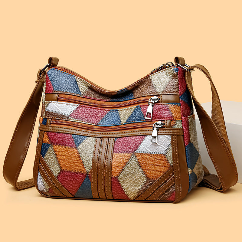 Women's multi-pocket patchwork crossbody bag with brown leather trim and adjustable shoulder strap