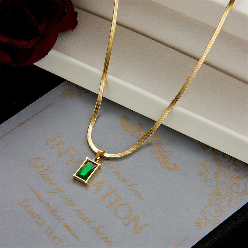 Gold-tone chain necklace with green square zircon pendant on a flat rectangular bail