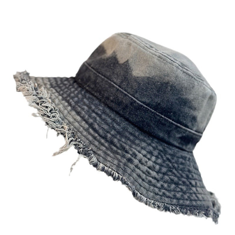 Dark wash denim bucket hat with frayed wide brim and distressed stitching