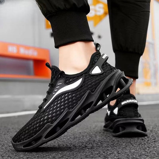 Black athletic shoes with white accents worn by a person on a street.