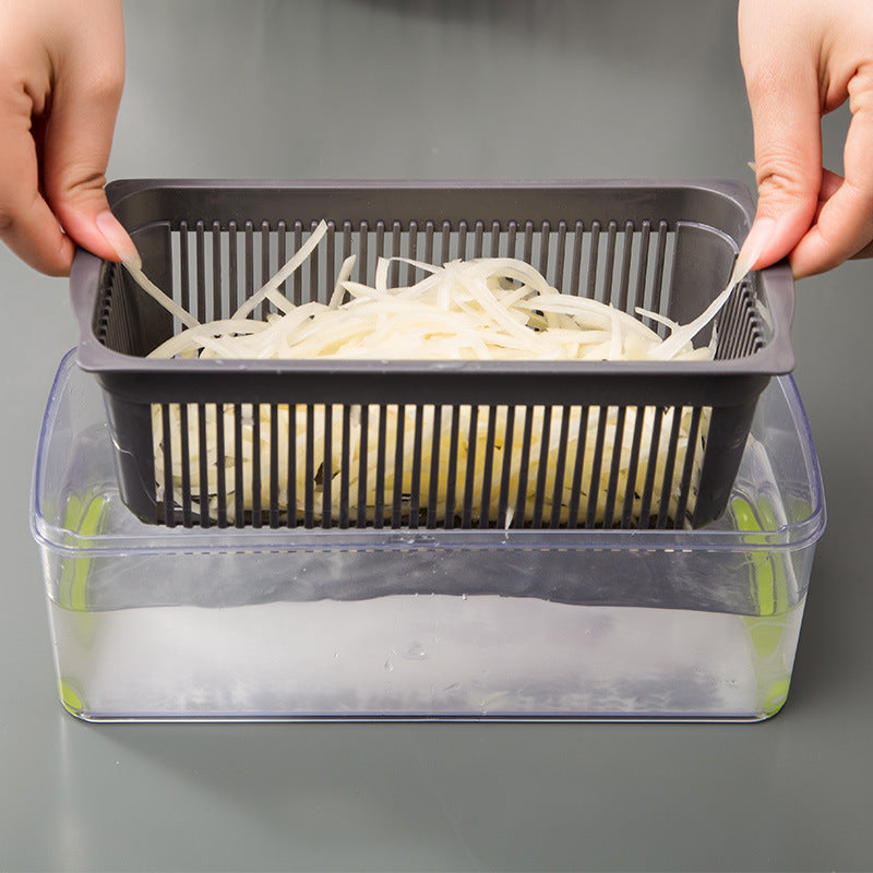 Vegetable cutter basket with green combs holding shredded white vegetables