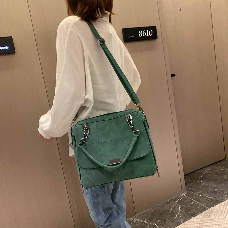 Women’s shoulder matte bag in green, worn crossbody with adjustable strap