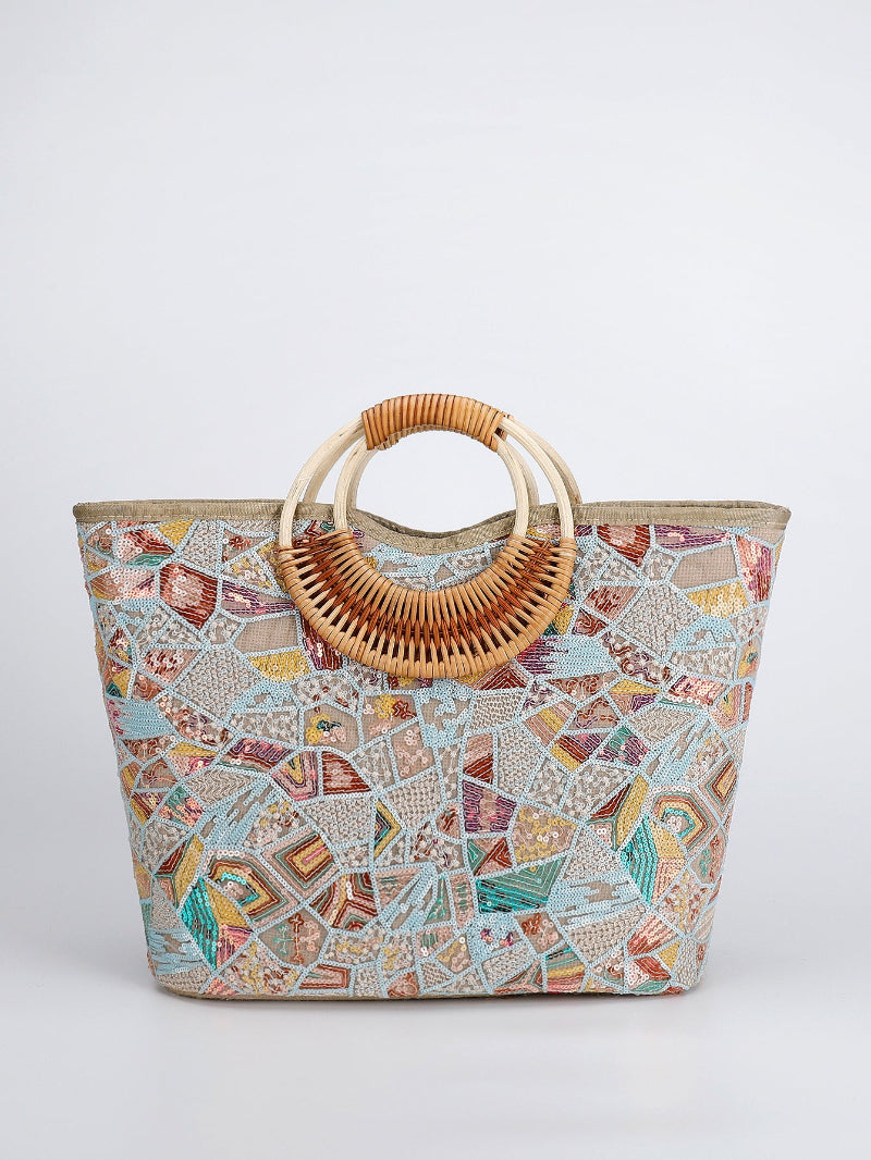 Large woven cotton tote bag with geometric mosaic print and woven rattan top handles, teal and orange