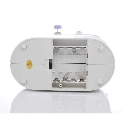 Mini sewing machine with open bobbin compartment showing metal interior