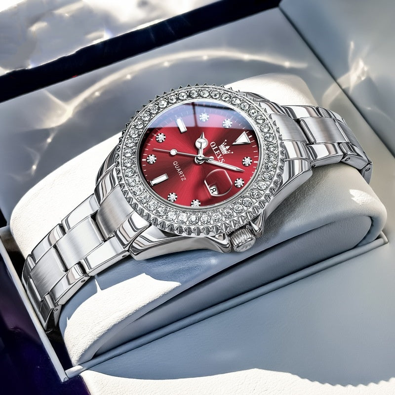 Quartz wristwatch with red dial, crystal bezel, and silver metal link bracelet