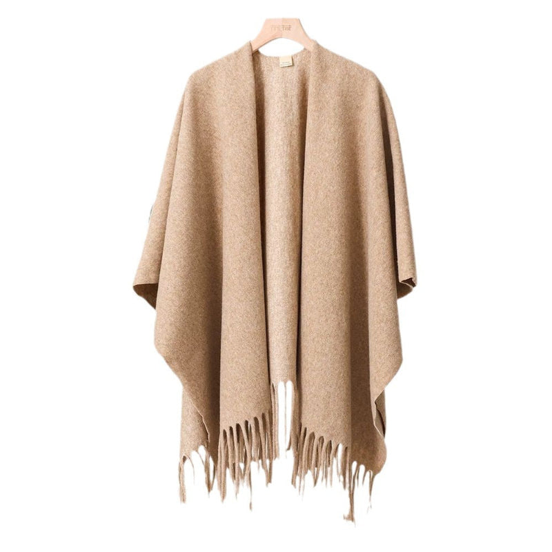 Tan tassel-fringe travel cape with draped front and open poncho neckline
