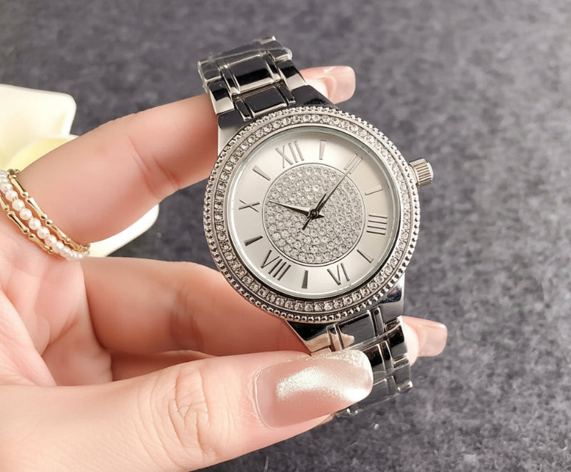 Silver bracelet watch with crystal bezel, white dial, and dark metal link band