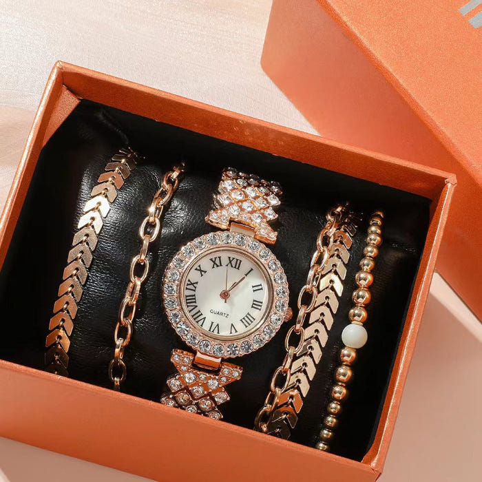 Rose-gold crystal watch with matching linked and beaded bracelets in black tray