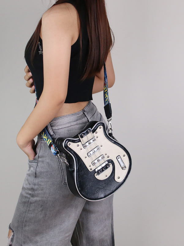 Small guitar-shaped crossbody bag with black-and-silver front and patterned strap