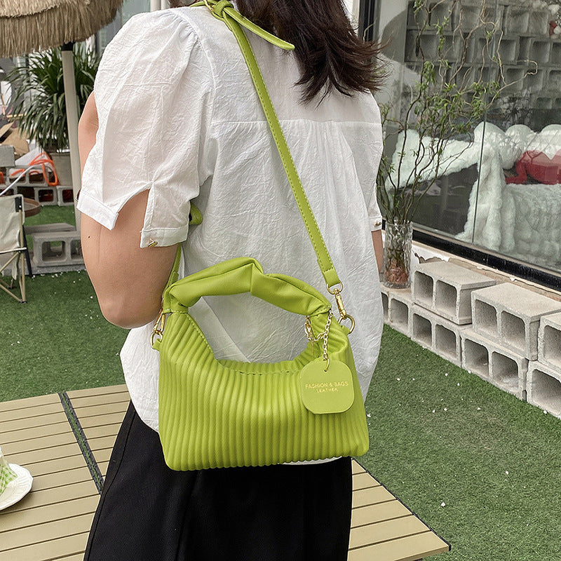 Lime green ribbed PU leather crossbody bag with chain strap and round charm tag