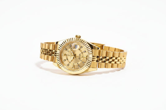 Gold wristwatch with a tag displaying price and certification details on a wooden surface.