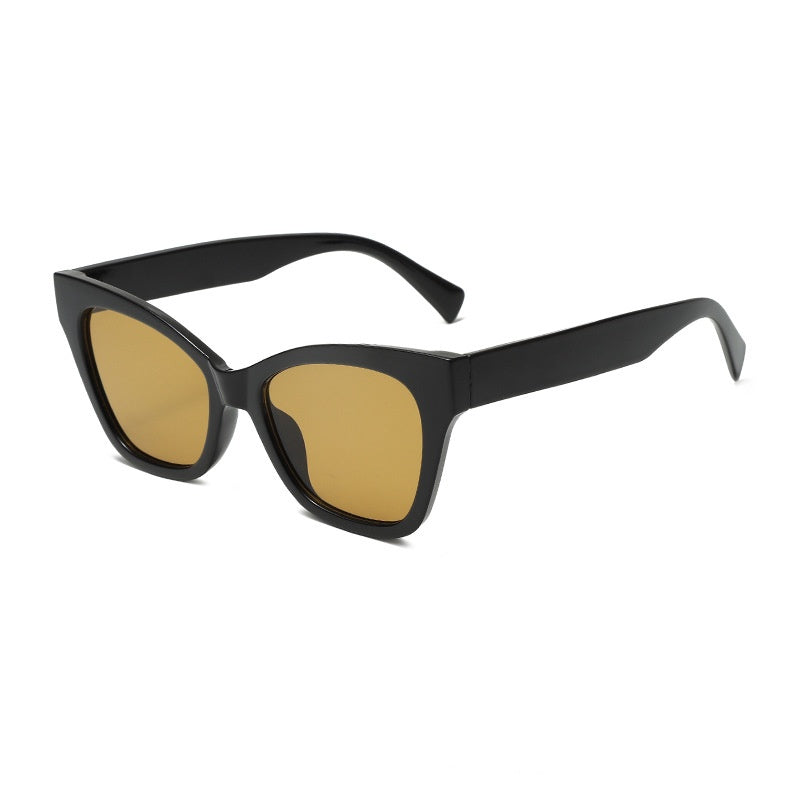 Black sunglasses with gold-tinted lenses and angular cat-eye frame