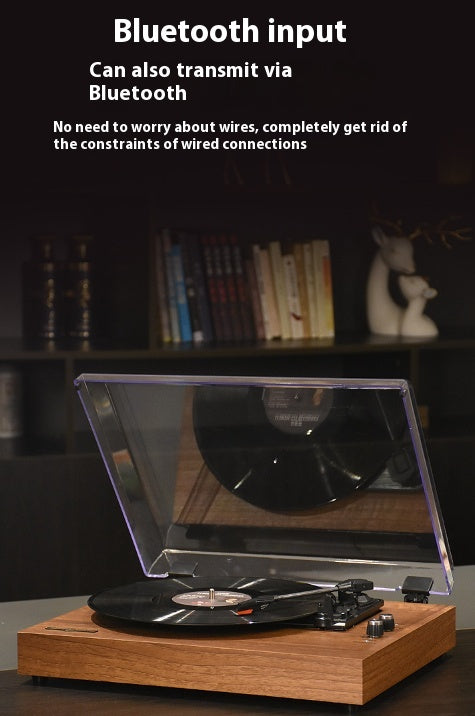 Retro Bluetooth vinyl record player with open clear dust cover and black vinyl on wooden base