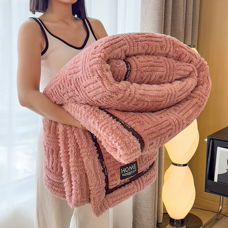 Plush velvet winter blanket in dusty rose pink with striped border and logo label