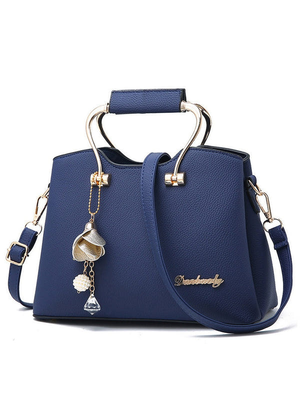 Navy blue PU leather handbag with top handles, crossbody strap, gold hardware, hanging charm