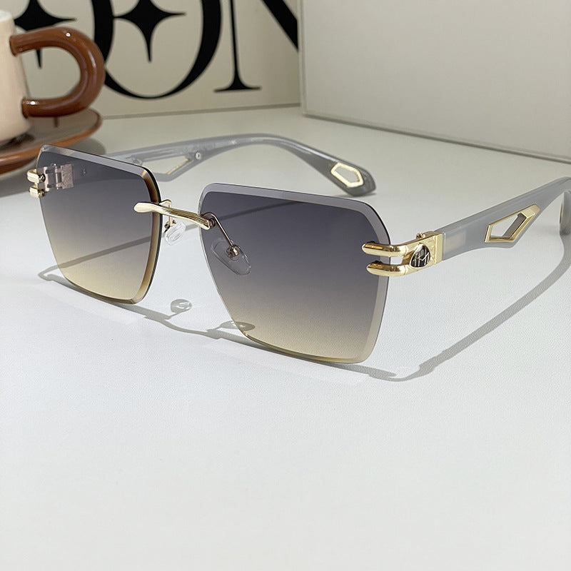 Square sunglasses with dark lenses, clear-blue-gray arms, gold-tone geometric side detail