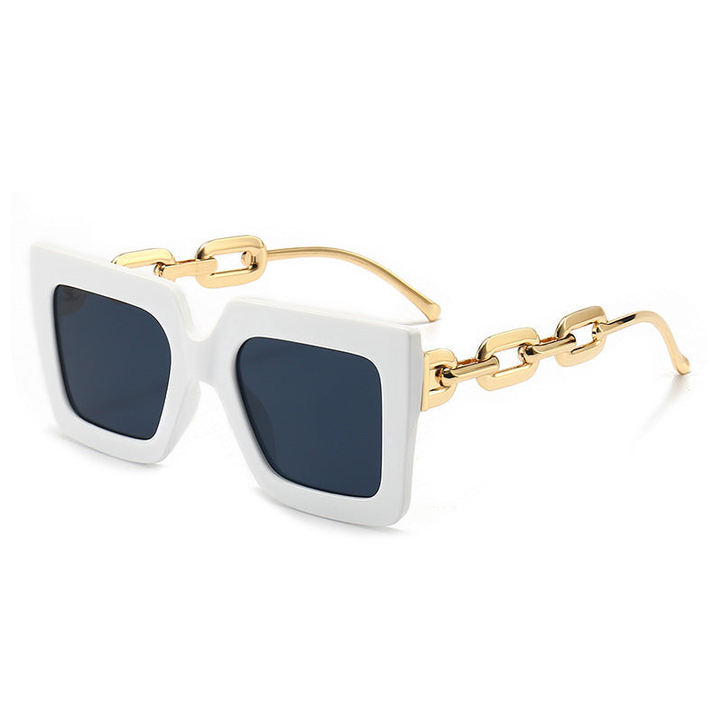 Square chain sunglasses with white frame, dark blue lenses, and gold chain arms.