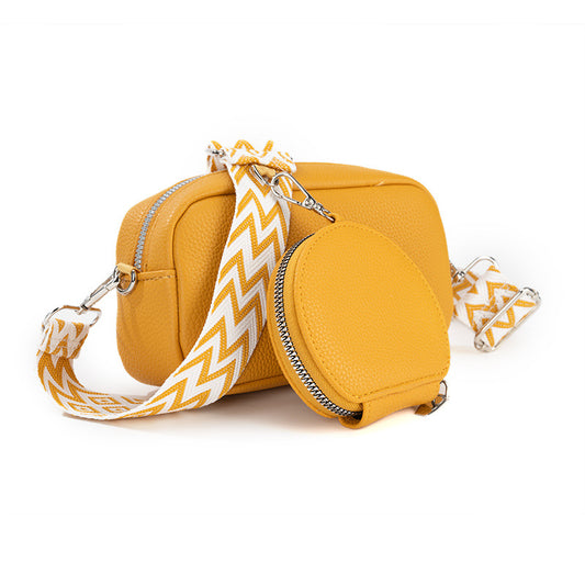 Yellow crossbody bag with a matching round pouch on a white background