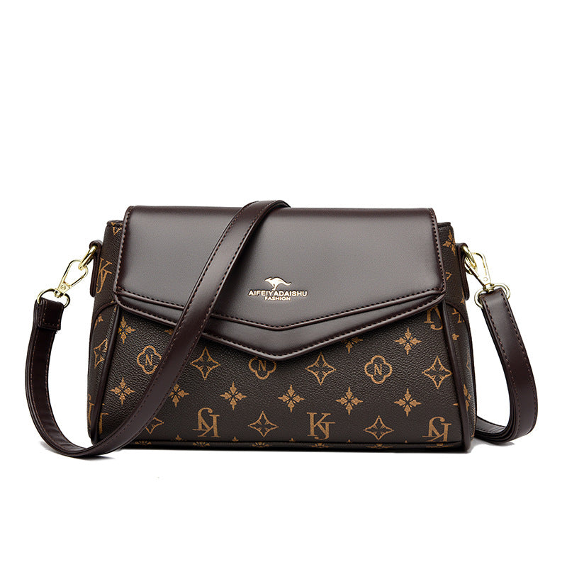 Dark brown monogram crossbody shoulder bag with dark flap, gold-tone hardware, adjustable strap