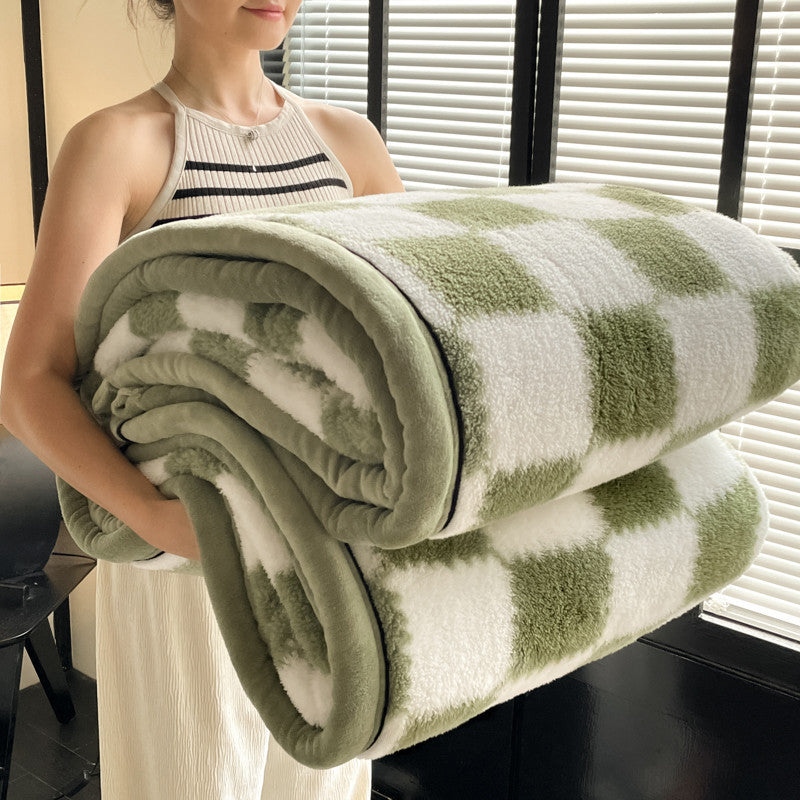 Velvet plaid blanket rolled, green square blocks on white, plush texture and HOME label