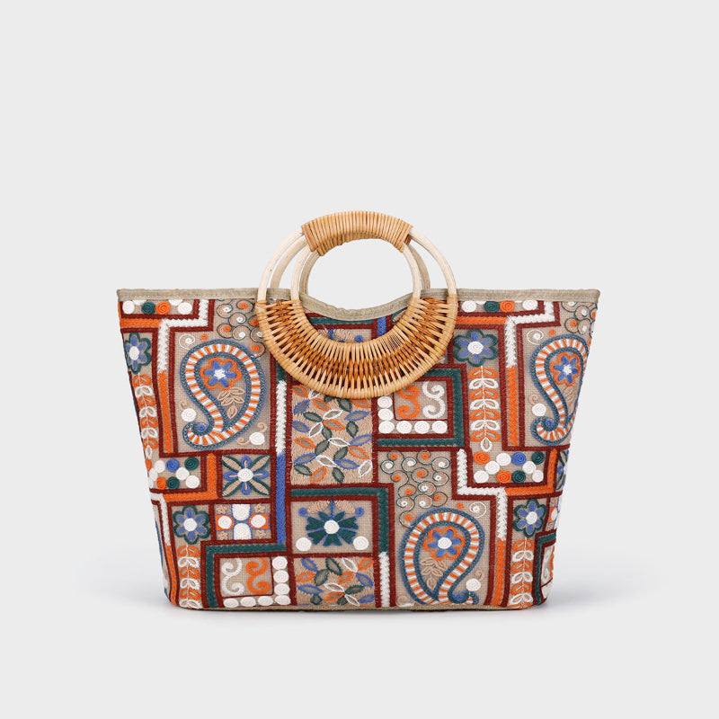 Large woven cotton tote bag with colorful tiled pattern and woven rattan top handles, orange and blue
