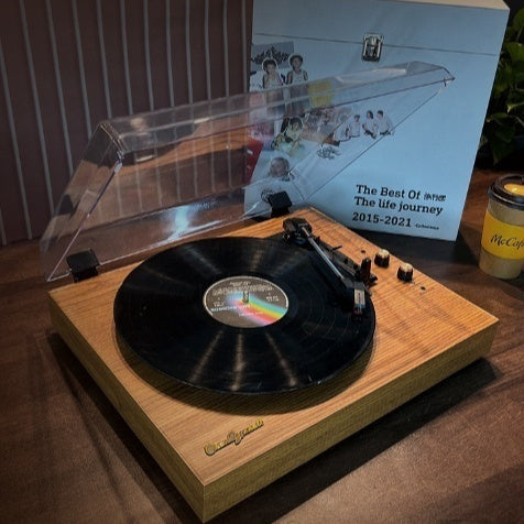 Retro Bluetooth vinyl record player with clear dust cover and black vinyl on wood base